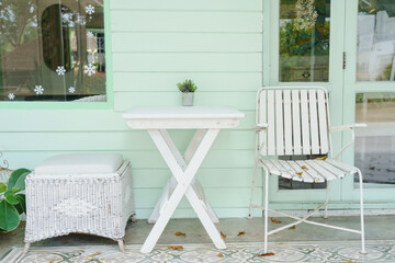 White chairs and table withe pastel green wooden wall , vintage style.