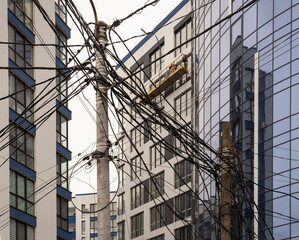 Randomly intertwined wires at a construction site against the backdrop of a new house.