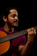 Obraz premium Man playing guitar with black background