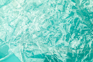 background from minted plastic film on colored paper of pure water color. concept of global ocean pollution, planet.