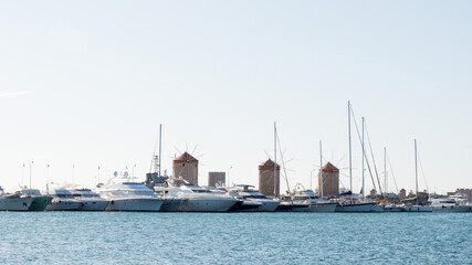 Rhodes harbor with three windmills and many yachts. Dodecanese, Greece