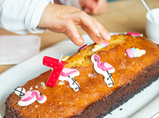 Child helping to prepare and decorate a birthday cake 