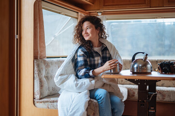 Couple in a checkered plaid roasting marshmallows on fire near the trailer home.