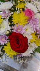 red roses with other flowers in bouquet in market 