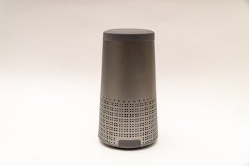 elongated cylinder-shaped speaker on a white background with bluetooth