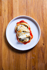 Roulade with eggplant, onion and basil in tomato sauce covered with motzarela. Italian cuisine dish.
