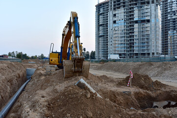 Excavator at construction site during laying sewer and main reticulation systems. Civil...