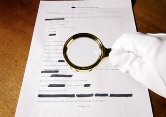 A spy looking at a (fake) secret document with a magnifying lens.
