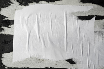 Scraps of white paper on a black plastered wall.