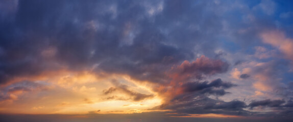 Dramatic sky with dark clouds during sunset.