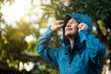 Young Asian man wearing raincoats in the outdoor.