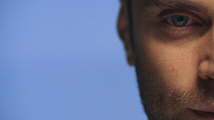 cropped view of man looking ta camera isolated on blue
