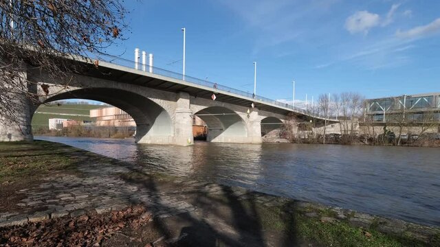 People Walking And Riding A Bike On The Bridge Of Peace On A Sunny Winter Afternoon. Flood On The River Main, In The Background Ist The Famous Congress Centre. 4k