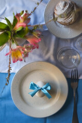 Beautiful holiday Easter table setting with flowers and eggs on linen tablecloth. Zero Waste Easter