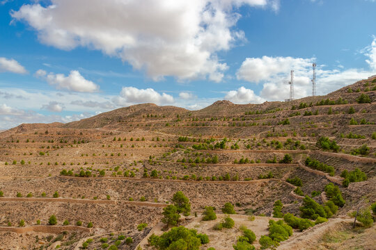 Lunar landscape in Atlas mountains in Toujane, Tunisia. Hilly slopes with stone terraces and sparse plant