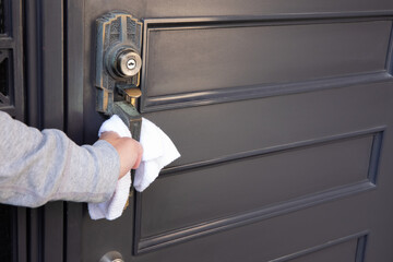 Disinfecting door knob by cleaner at the entrance