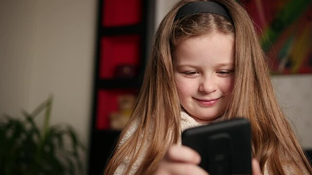 Young girl watching a video on her mobile phone she is watching funny videos