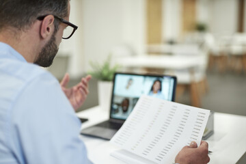 Boss having meeting online and holding documents