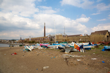 Fototapeta na wymiar MARCH 6, 2021 - NAPOLI, ITALY - Bagnoli, Coroglio beach, in the west part of Napoli, ex area of ​​the Italsider factories. In the background the remains of the 
