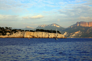Sailboat on the blue sea with the background of the coast and mountains, Parc National des Calanques, Marseille, France
