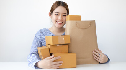 Young woman embraced a mailbox and a brown paper bag in preparation for the delivery of her order, New business style for young people working at home and owning businesses, Sell online concept.