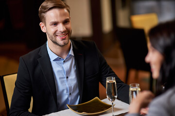 Joyous young man having a restaurant date with a woman