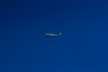 The plane flies in the blue sky