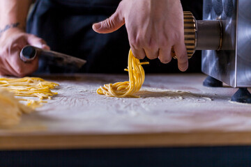 Manufacture Pasta Machine. Home Made Pasta. Italian Food. Italy. Spaghetti on the table. Wheat flour spaghetti