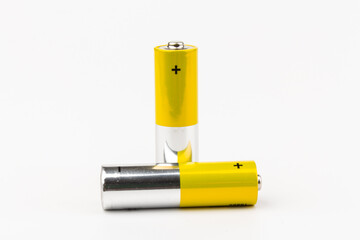 Photo of gray-yellow alkaline AA batteries on white background. Recycling of rechargeable NiMH...