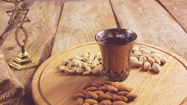 hands puts the table on a round stand with nuts and sets the kiddush wine. Horizontal panorama