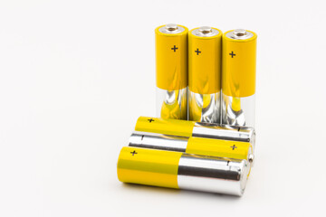Photo of gray-yellow alkaline AA batteries on white background. Recycling of rechargeable NiMH...