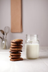Chocolate chip cookies with milk on burlap and rustic wooden table