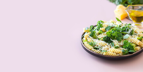 Fusilli with with broccoli, basil and parmesan cheese on beige background. Proper nutrition. Sports nutrition. Dietary menu.
