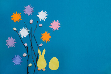 Fototapeta na wymiar easter card made with your own hands,a hare with an egg and branches with flowers