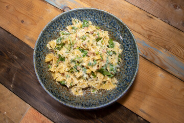 A delicious plate of Pancetta Parmesan and Pea Pasta on a wooden kitchen table