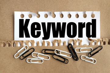 KEYWORDS Concept. text on white paper over torn paper background.