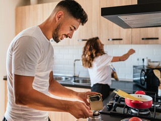 Happy couple preparing food together in the kitchen at home