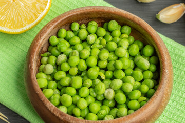 Close-up of a small amount of green peas in a wooden plate
