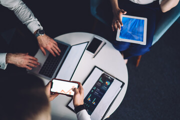 Anonymous coworkers surfing gadgets in office