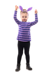 Cute happy girl with bunny ears hat celebrating Easter with raised hands looking at camera. Full body isolated on white background