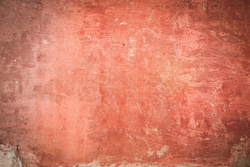 The background is plastered and painted red wall. A shabby, weathered surface, chipped on the surface