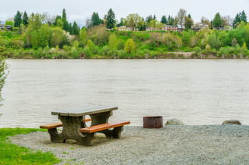 Fototapeta na wymiar Picnic Table in Park with river or lake background.