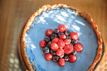 Berry nut cheesecake on a wooden chair with a sunshine, Close-up view from above