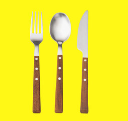 Set of cutlery knife fork spoon isolated on yellow background