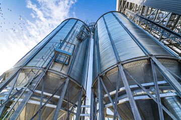 Big metallic container on blue sky. Fuel tank in big factory. Large towers at navy sky.
