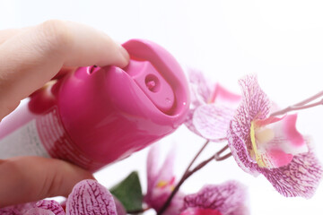 Pink spray bottle of air freshener and a beautiful orchid