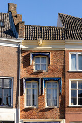 Brick original medieval exterior facade of Hanseatic city center Zutphen, The Netherlands, against a clear blue sky. Architectural detail of European tourism destination.