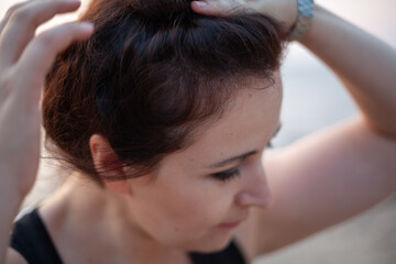 Fototapeta premium Beautiful brown-haired woman straightens her hair