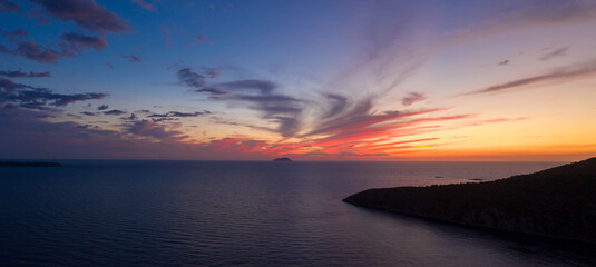 Aerial panorama drone shot of sunset burning sky clouds on Komiza town over Vis Island in Croatia Summer