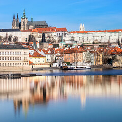 Charles Bridge, St. Vitus Cathedral and other historical buildings in Prague reflected in the river